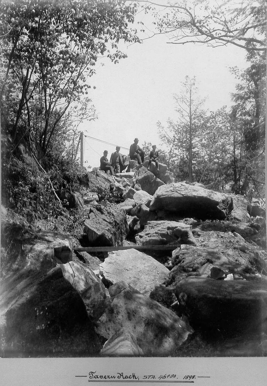 Men sitting atop large rocks